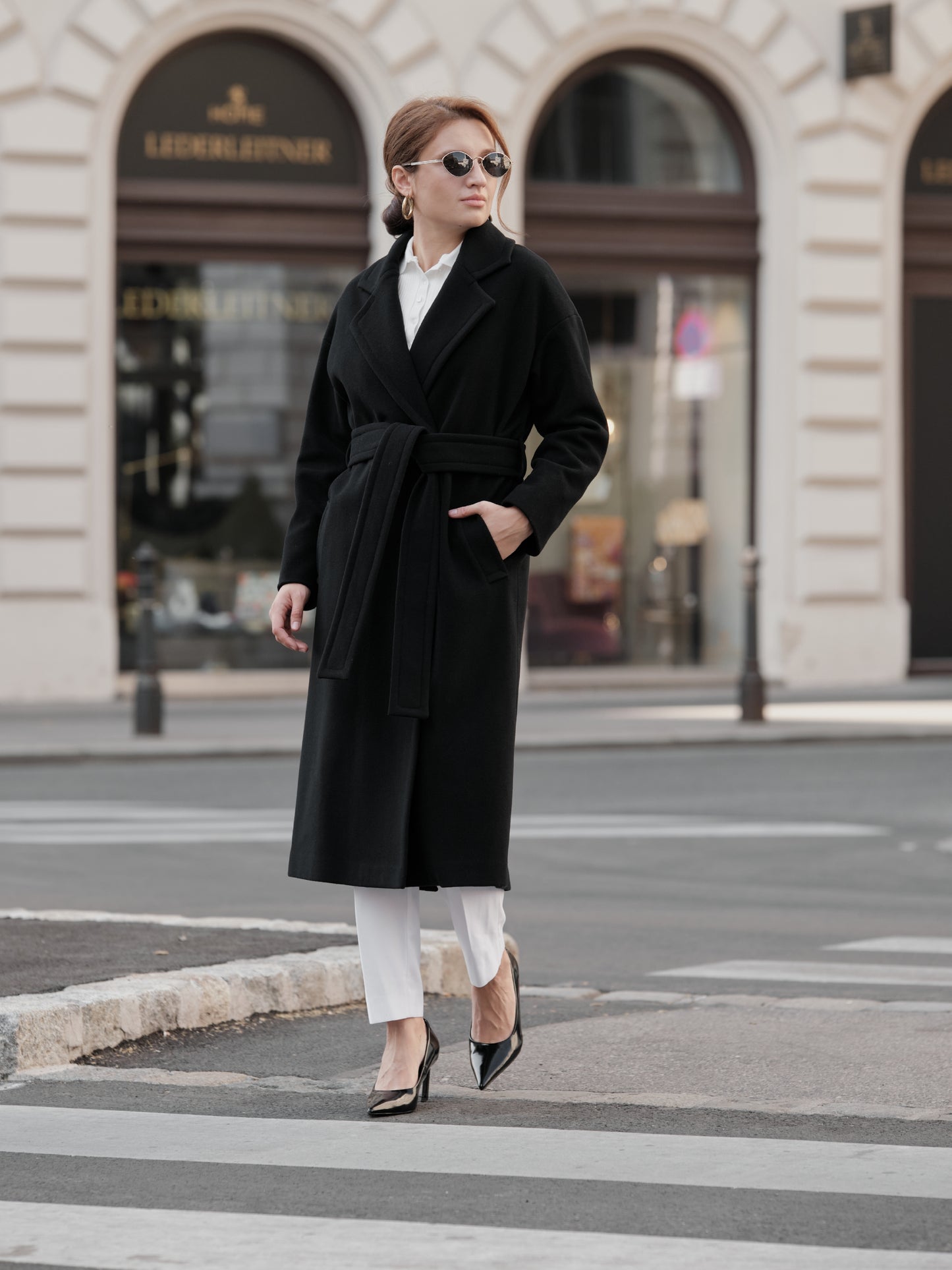 Women's Black Wool Coat with Belt. Model featuring a lapel collar and welt pockets. CHELIE Women's Black Wool Coat with Belt. Model featuring a lapel collar and welt pockets. CHELIE